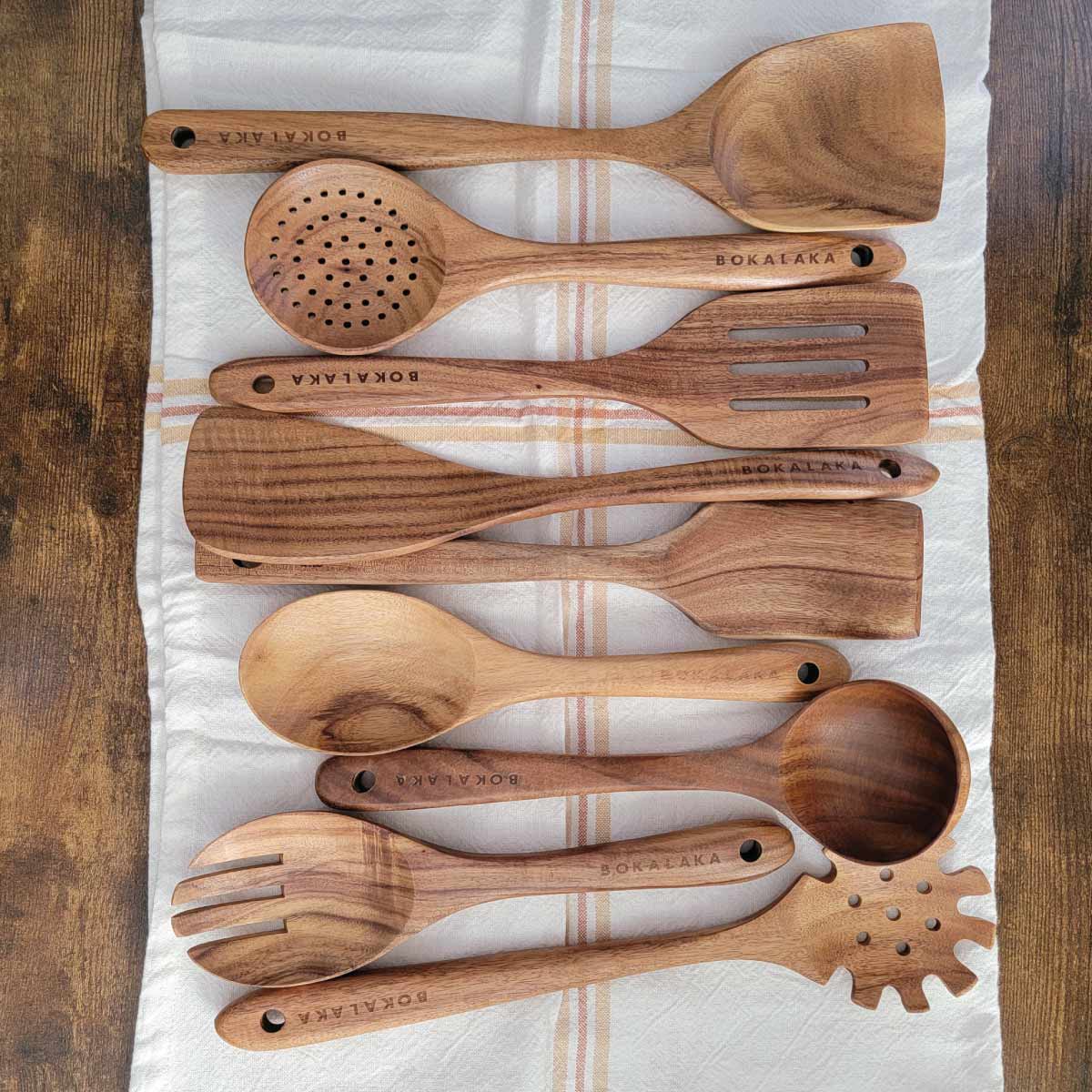 Set of 9 wooden serving utensils from spatulas and spoons to ladles and a spaghetti server.